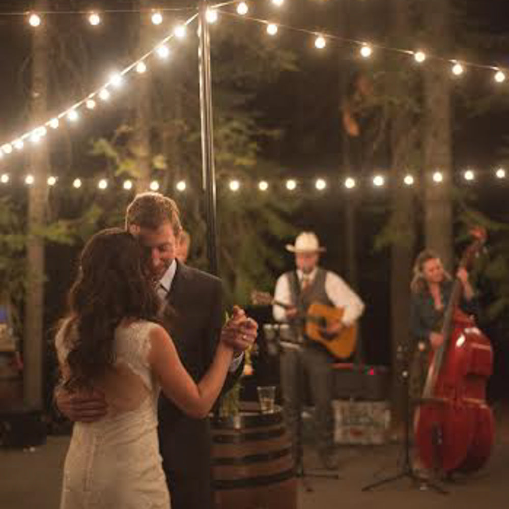 String lights at wedding with couple dancing and band