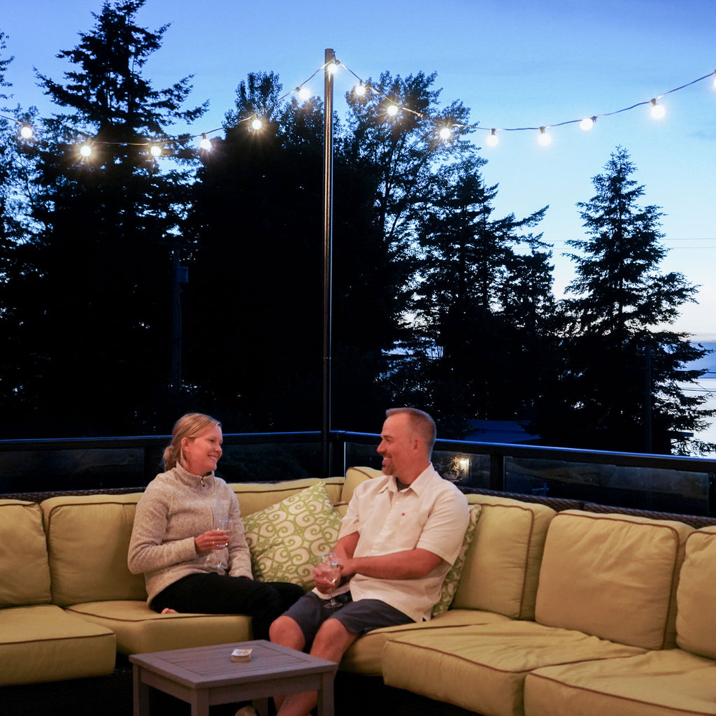 Couple on couch outdoors with string lights